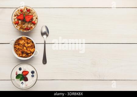 Mosaik aus Frühstücksschalen mit Joghurt, Müsli und Haferbrei mit Früchten auf Holzoberfläche Stockfoto