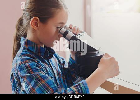 Kinder erlernen Wissenschaft durch praktische Aktivitäten mit einem Projektor in einem Klassenzimmer Stockfoto