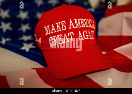 Ein rotes „Make America Great Again“-Cap vor der US-Flagge als Symbol für die politische Unterstützung Donald Trump in den Vereinigten Staaten. Stockfoto