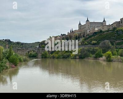Historisches Stadtbild mit der Festung Alcázar, dem Fluss Tejo und der Brücke Puente de Alcántara, Toledo, Kastilien-La Mancha, Spanien, April 2024 Stockfoto