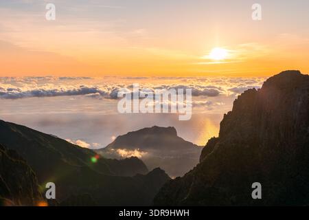 Sonnenaufgang über dem Wolkenmeer am Pico do Arieiro Madeira Portugal vom hohen Kamm aus gesehen, warmes Licht über dem Atlantischen Horizont vom Aussichtspunkt ab Stockfoto
