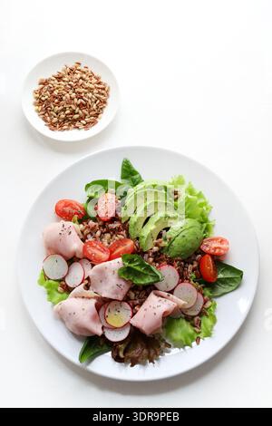 Frischer und gesunder Mischkornsalat mit Avocado, geschnittenem ​​turkey oder Huhn, Kirschtomaten, Radieschen, frischen Salatblättern und Baby-Spinat. Stockfoto