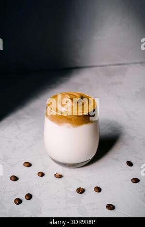 Geschäumtes Kaffeegetränk in einer Glasschale auf grauem Hintergrund Stockfoto