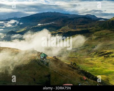 Aus der Vogelperspektive eines einsamen Hauses, das auf einem Hügel zwischen wirbelnden Wolken und fernen Bergen thront und eine Szene der ruhigen Isolation schafft, Manizales, C Stockfoto