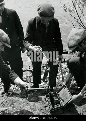 Dieses Foto, das vor 1935 von Wiel van der Randen aufgenommen wurde, zeigt Männer, die Rattenleichen entlang eines Kanals in Amsterdam sammeln. Die Ratten wurden im Rahmen einer gezielten Vernichtungskampagne mit Gas getötet. Das Bild zeigt die Organisation, die Arbeit und die Verfahren, die mit der städtischen Schädlingsbekämpfung verbunden sind, und zeigt die historischen Methoden des Managements von Nagetierpopulationen und der Gewährleistung der öffentlichen Hygiene in einer städtischen Umgebung während der 1930er Jahre Stockfoto