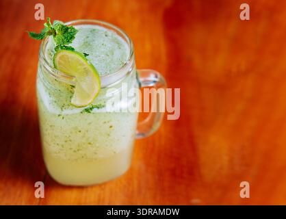 Erfrischende Limonade mit Minze auf Holztisch. Limonadengetränk auf Holztisch Stockfoto