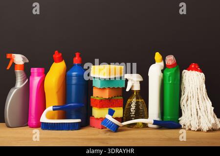 Sammlung von Reinigungsmaterialien auf einem Tisch mit verschiedenfarbigen Schwämmen und Flaschen Stockfoto