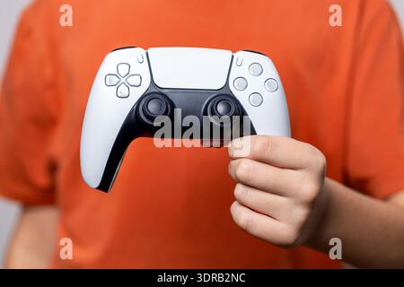 Gamer Hand mit Videospielkonsolen-Controller. Spielkonzept. Nahaufnahme von Kinderhänden, die das Videospiel spielen. Kind, das einen Game-Controller hält Stockfoto
