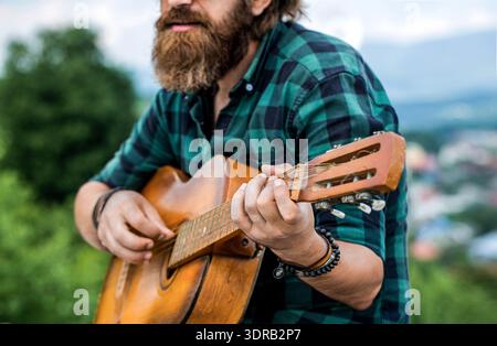 Akustikgitarren spielen. Musikkonzept. Akustische Gitarren. Männlicher Musiker, der Gitarre spielt, Musikinstrument. Musik Lifestyle Mann spielt Gitarre Natur Stockfoto