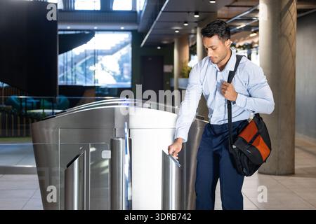 Betreten Sie das Bürogebäude, Geschäftsmann mit Schlüsselkarte am Sicherheitsdrehkreuz Stockfoto
