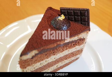Nahaufnahme: Ein Stück aromatischer Schokoladen-Chiffon-Kuchen auf einer weißen Platte Stockfoto