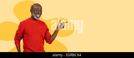 Der ältere Mann lächelt und zeigt nach rechts, während er einen roten Pullover vor gelbem Hintergrund trägt Stockfoto
