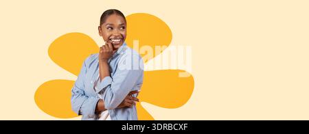 Frau lächelt und posiert im Studio mit orangefarbenem Muster hinter ihr, während sie ein lässiges Blue Shirt trägt Stockfoto