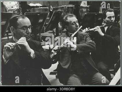 Dieses Foto von Wiel van der Randen aus dem Jahr 1938 zeigt Flöten- und Piccolo-Spieler des Royal Concertgebouw Orchestra während einer Probe in Amsterdam, Niederlande, im Jubiläumsjahr des Orchesters. Musiker halten ihre Instrumente mit Notenständern und Notenblättern vor, die im Holzbläserabschnitt angeordnet sind. Das Bild zeigt professionelle Orchesterproben, Instrumentierung und niederländische klassische Musikpraxis im frühen 20. Jahrhundert. Stockfoto
