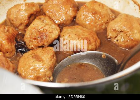 Hausgemachte Fleischbällchen, die in Soße aus der Nähe kochen. Traditionelle Komfortzubereitung und Hausmannskost in der Küche. Stockfoto