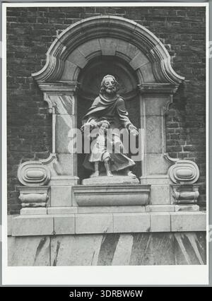 Am 21. Januar 1948 wird in Sittard, Niederlande, eine Statue des Heiligen Josef in der Seitenfassade des St. Michielskerk aufgestellt. Das Foto zeigt katholische religiöse Kunst, architektonische Integration, Heiligenverehrung, Kirchendekoration, regionales Erbe, das religiöse Leben der Nachkriegszeit und die Verwendung skulpturaler Elemente zur Darstellung christlicher Figuren in der kirchlichen Architektur. Stockfoto