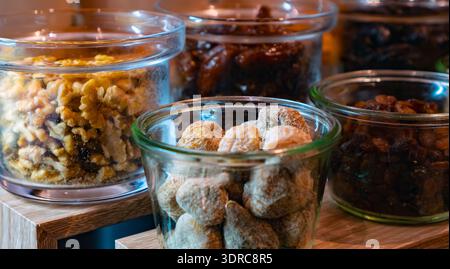 Verschiedene Nüsse und getrocknete Früchte in Gläsern. Stockfoto