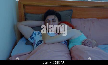 Junge Paare schlafen friedlich zusammen in einem gemütlichen Bett Stockfoto