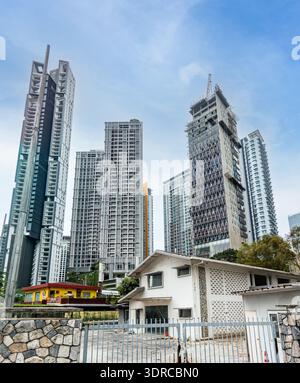 Kontrast zwischen traditioneller, flacher Architektur und moderner Hochhausentwicklung in einer dichten städtischen Umgebung, Kuala Lumpur, Malaysia Stockfoto