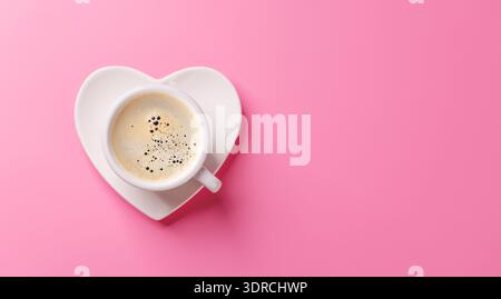 Eine bezaubernde Kaffeetasse auf einer Untertasse in Herzform Stockfoto