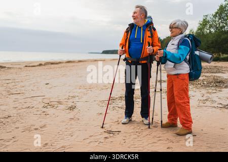 Wandertourismus Abenteuer. Senior Paar Mann Frau genießt Outdoor Erholung Wandern am Strand. Glückliche alte Leute, die Rucksacktouristen wandern Stockfoto