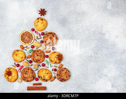 Kulinarischer Hintergrund von Keksen mit Preiselbeeren, Schokoladenstückchen, Mandeln und Gewürzen in Form eines Weihnachtsbaums. Köstlich Stockfoto