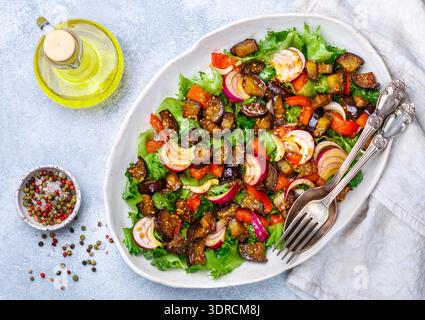 Frischer vegetarischer Gourmet-Salat aus Salat, gebackener Aubergine, Tomaten, roten Zwiebeln mit Dressing aus Olivenöl und Gewürzen. Selektiv Stockfoto