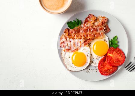 Frühstück mit Spiegeleiern, Speck und Kaffee Stockfoto