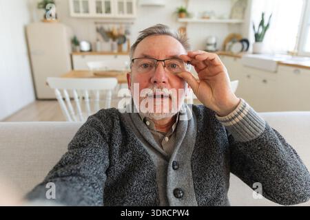 Glücklicher älterer Mann mittleren Alters, der mit Freunden und Familie im Videoanruf spricht. Lachender reifer, alter Großvater, der Spaß hat, zu sprechen Stockfoto