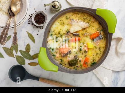 Cremige Fischsuppe mit Lachs, Kartoffeln, Zwiebeln, Karotten, Petersilie und Gewürzen in einem Topf. Kalakeitto. Lohikeitto. Traditionell Stockfoto