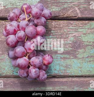 Ein Haufen rosafarbener Trauben auf Holzbrettern Stockfoto