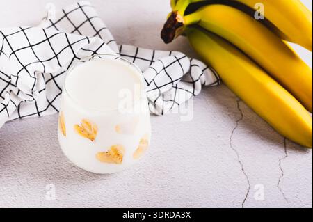 Banane vegane Alternative Milch im Glas und Obst auf dem Tisch Stockfoto