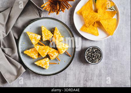 Gefälschte Weihnachtsbäume aus Dreieckskäse in Nacho zerbröckeln auf einem Teller von oben Stockfoto