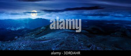 Wunderschöne Landschaft der Berglandschaft in einer Sommernacht. Panoramablick auf den großen Kamm im verfleckten Vollmondlicht. alpine Landschaft mit durchgehendem Weg Stockfoto