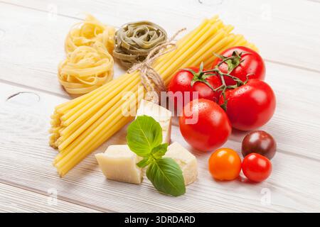 Nudeln, Tomaten, Basilikum auf Holztisch Stockfoto