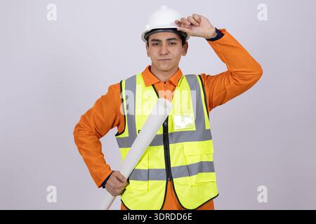 Fröhlicher Bauarbeiter posiert mit Blaupausen Stockfoto