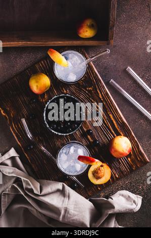 Eiscocktail mit schwarzer Johannisbeere und Nektarine in Gläsern auf dem Tisch und vertikaler Blick Stockfoto