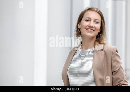 Porträt einer jungen erwachsenen Geschäftsfrau mittleren Alters im formellen Anzug draußen. Glückliche, selbstbewusste, elegante Geschäftsfrau, weibliche Person. Finanziell Stockfoto