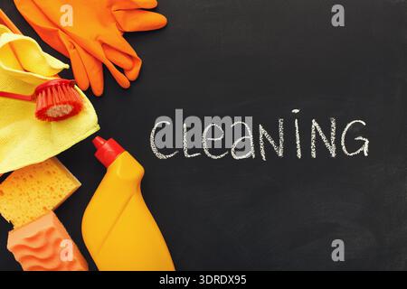 Reinigungszubehör und -Werkzeuge auf einer schwarzen Oberfläche für Haushaltsaufgaben und -Aufgaben Stockfoto