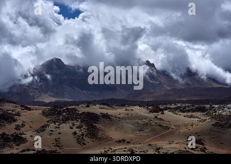 Der Berg Guajara erhebt sich dramatisch durch schwirbelnde niedrige Wolken über den vulkanischen Bimshügeln und Lavafeldern des Las Cañadas Caldera-Bodens, Photo g Stockfoto