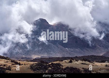 Der Berg Guajara erhebt sich dramatisch durch schwirbelnde niedrige Wolken über den vulkanischen Bimshügeln und Lavafeldern des Las Cañadas Caldera-Bodens, Photo g Stockfoto