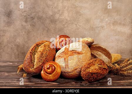 Frisch gebackene Backwaren auf hölzernem Hintergrund. Hausgemachtes Vollkornbrot, verschiedene Arten von rundem Sauerteigbrot mit cr Stockfoto