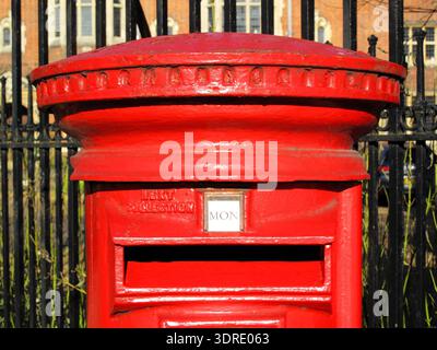Nahaufnahme eines traditionellen roten britischen Royal Mail-Säulenkastens in London mit dem Sammelplatz für Briefe, Retro-Straßenmöbel und Trav Stockfoto