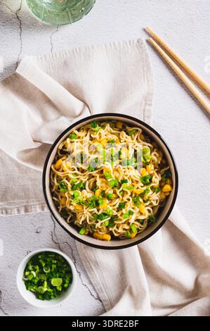 Eine Schüssel mit Instant-Nudeln und Gemüse auf der Tischplatte und vertikaler Ansicht Stockfoto