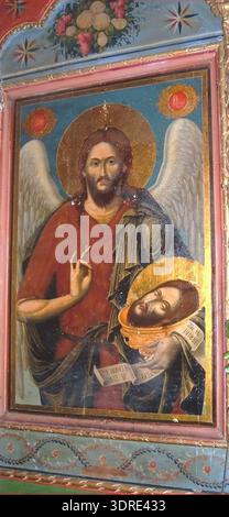 Dieses Symbol in der Karivis-Kirche aus dem Jahr 1840 zeigt den Heiligen Johannes den Täufer, begleitet von den Heiligen Cosmas und Damian. Das in Tempera auf Holz gemalte Symbol mit vergoldeten Akzenten repräsentiert östliche orthodoxe Ikonographie, religiöse Symbolik und Andachtskunst aus dem 19. Jahrhundert. Es dokumentiert kirchliche Praktiken, ikonographische Konventionen und das künstlerische Erbe der Karivis-Kirche. Stockfoto