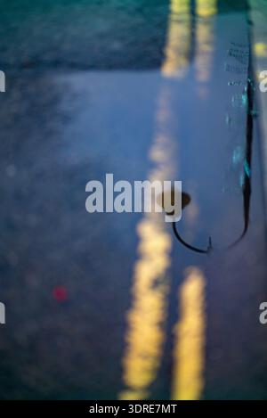 Straßenlaterne-Reflexion in der Regenpfütze Stockfoto