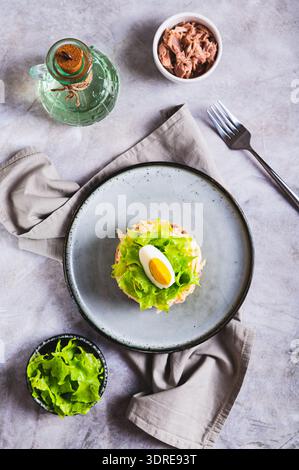 Herzhafter Thunfischsalat in Dosen mit Gemüse und Kräutern auf einem Teller oben und vertikal Stockfoto