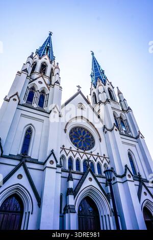 Die Kirche ist sehr hoch und hat viele Fenster. Die Fenster sind blau und das Gebäude weiß Stockfoto
