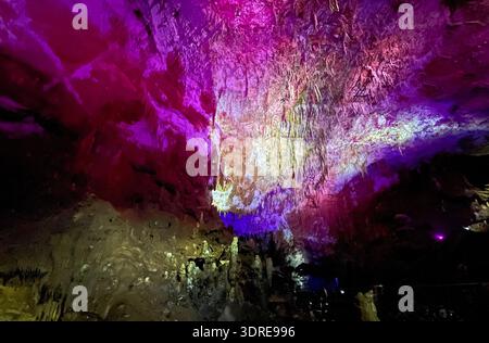 Kristalline Höhle mit schimmernden, vielfarbigen Stalaktiten und Stalagmiten. Coole magische Fantasy unterirdischer Wunderland Hintergrund Stockfoto