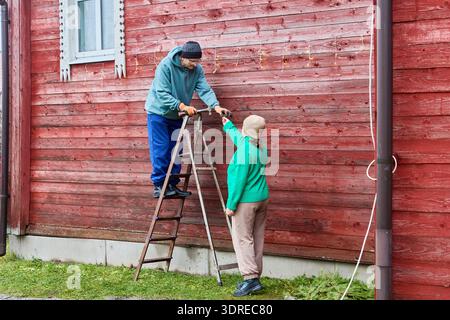 Die Dekoration des Bauernhauses für ein Weihnachtspaar hängt eine Girlande an der Außenseite. Stockfoto